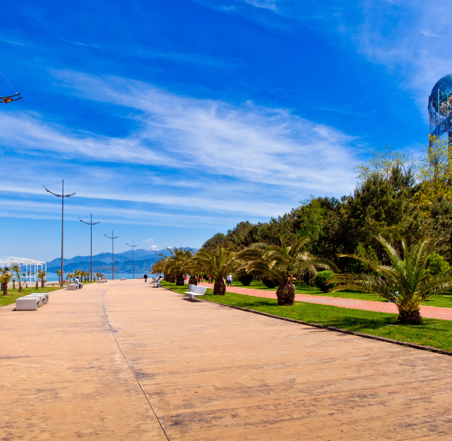 Promenada w Batumi w Gruzji z widokiem na morze. Wzdłuż deptaku rosną palmy.
