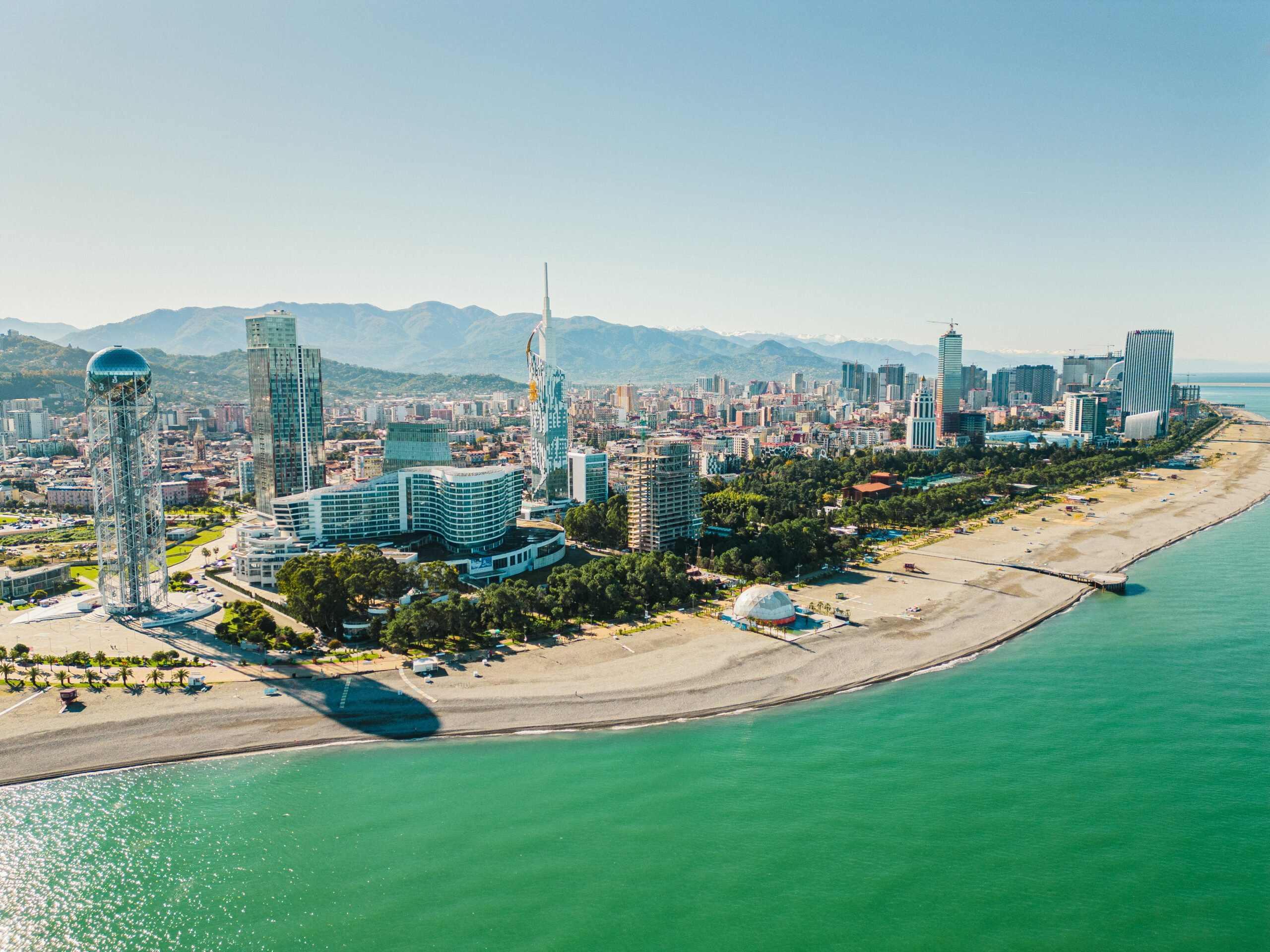 Widok z góry na nowoczesną infratrukturę Batumi w Gruzji i plażę. W tle góry.