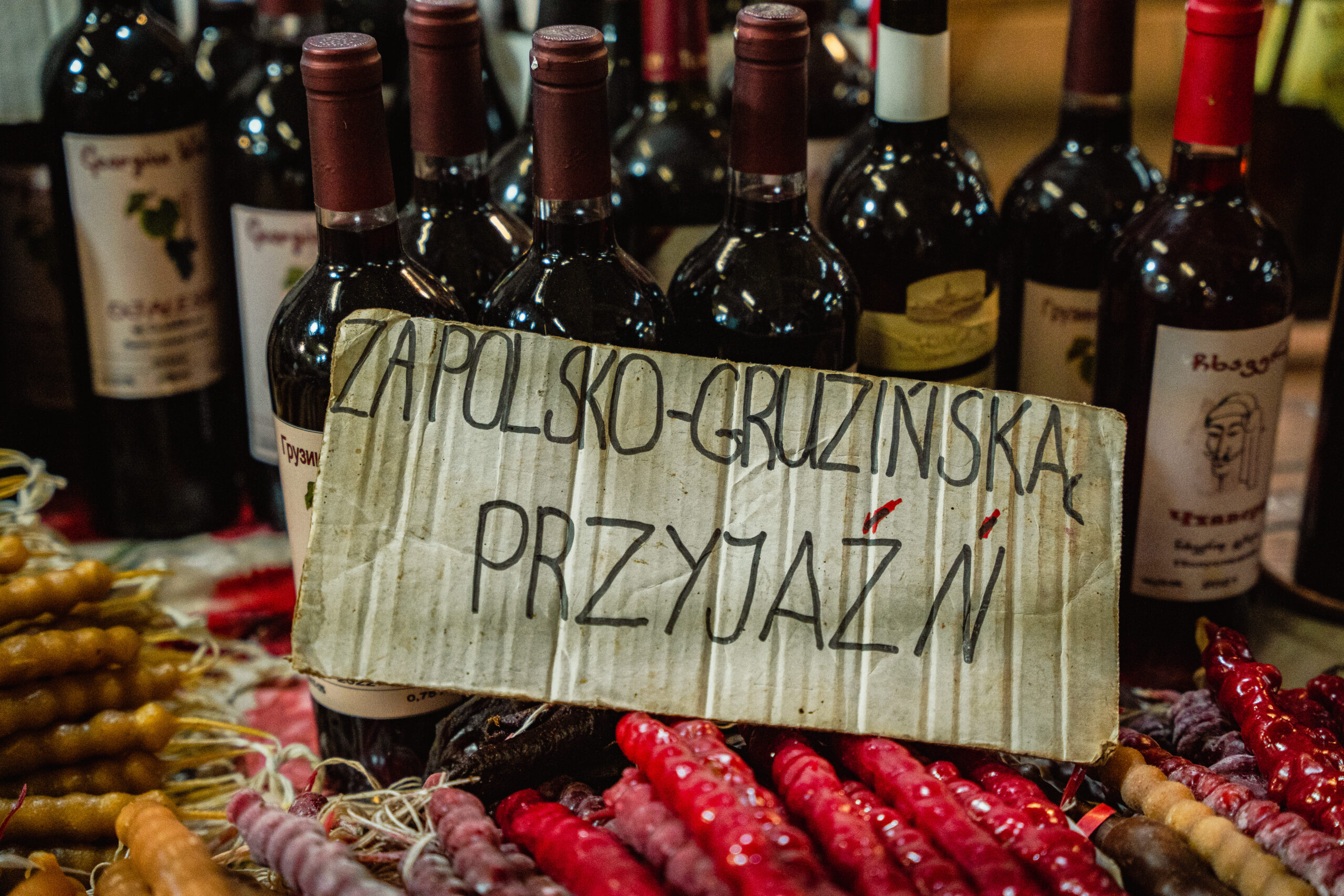 napis "za polsko-gruzińską przyjaźń" na tle wina geuzińskiego i czurczcheli.